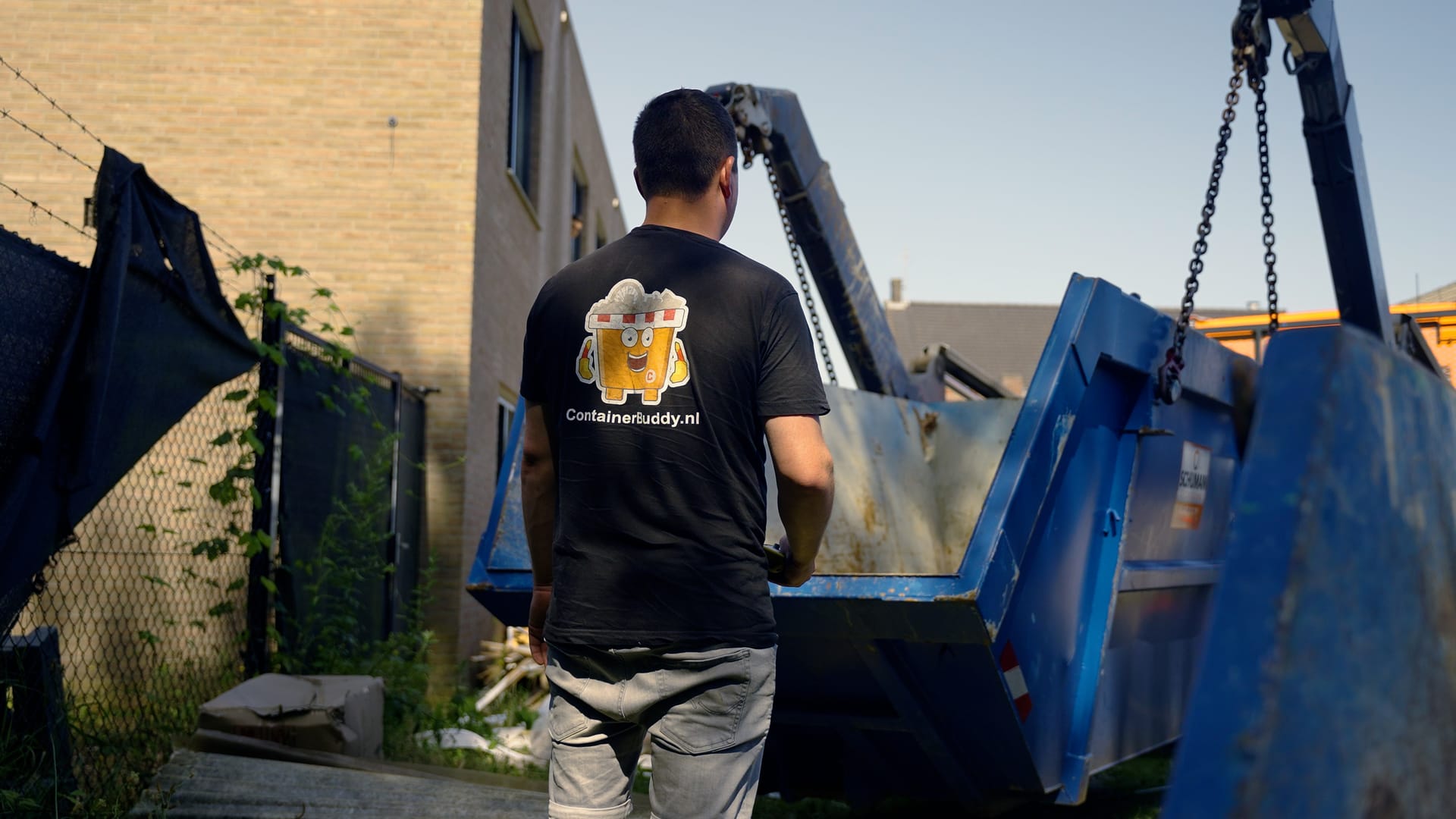 Medewerker van ContainerBuddy plaatst een afzetcontainer in de wijk